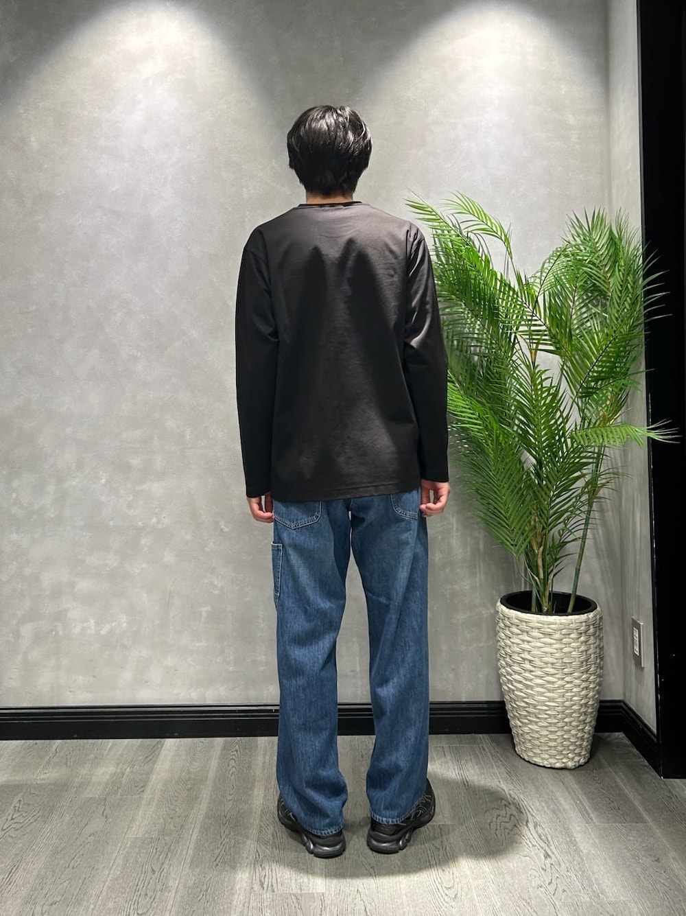 ブラック系のブルゾン、ブラック系のTシャツ/カットソー、ブルー系のデニムパンツを着用したメンズの春コーディネートの6枚目の写真