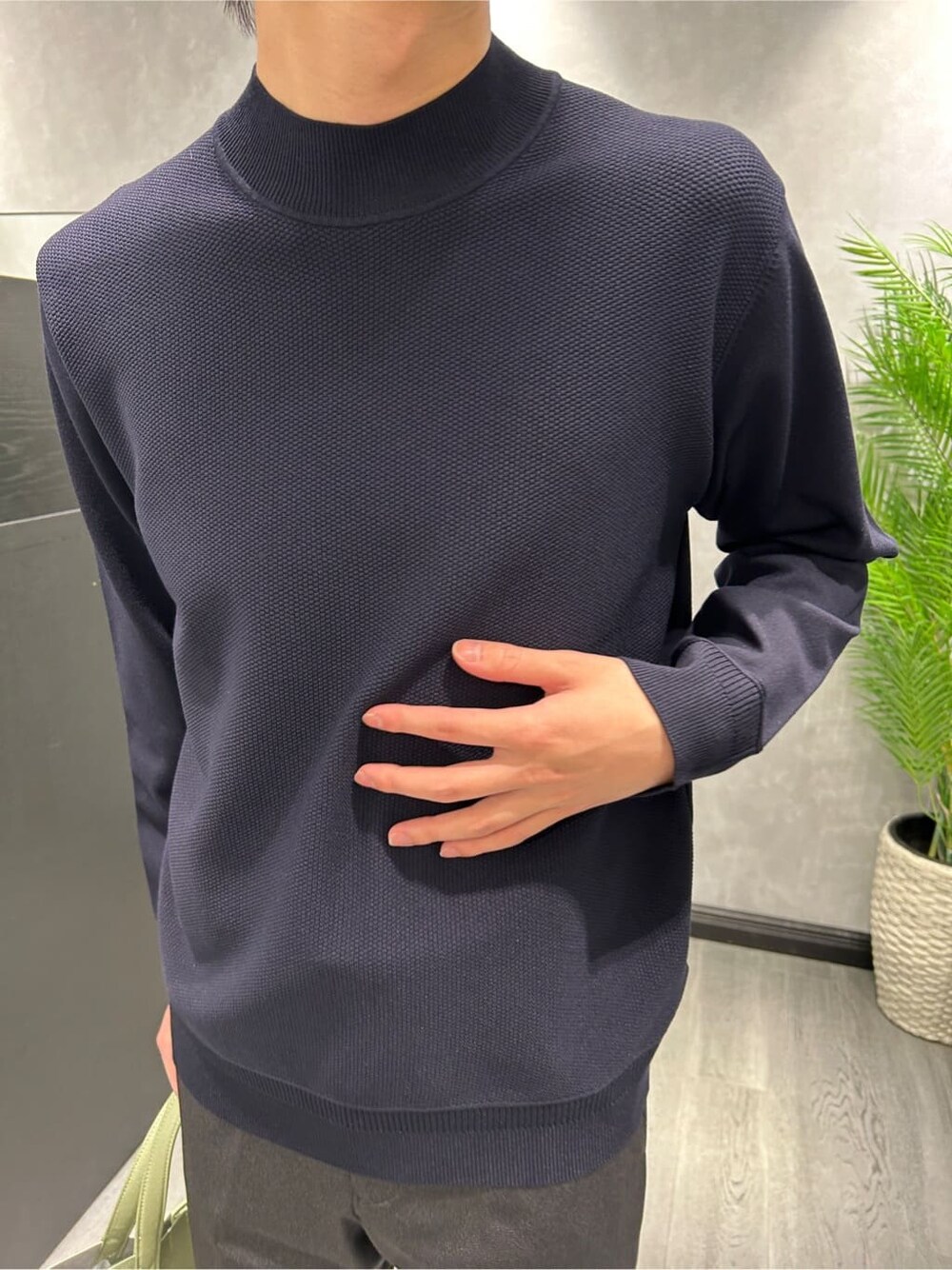 グレー系のその他アウター、ブラック系のスラックス、ブルー系のニット/セーターを着用したメンズの冬コーディネートの7枚目の写真