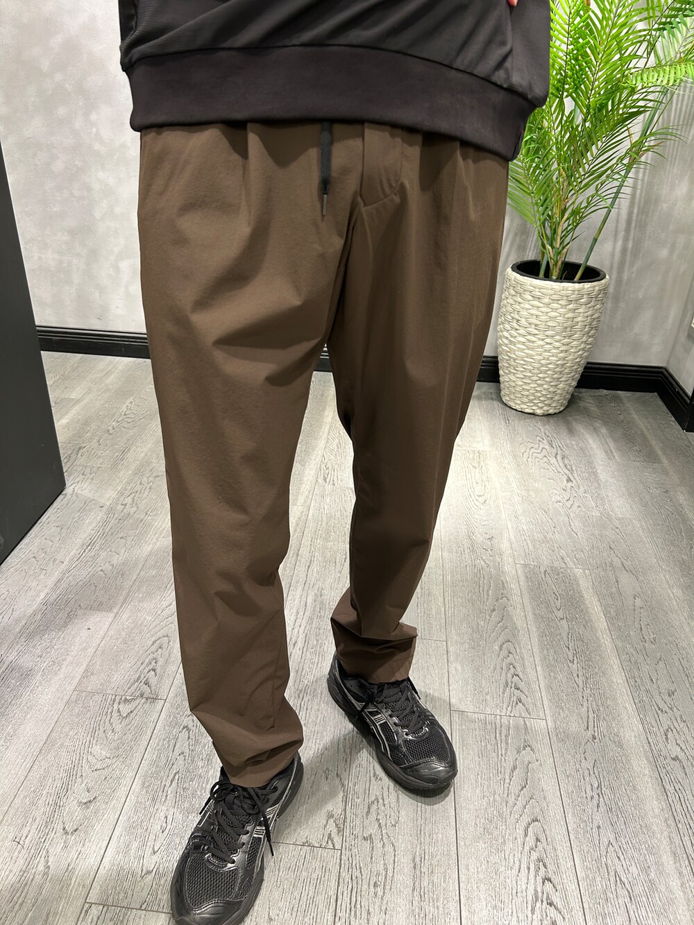 グレー系のテーラードジャケット、ブラック系のTシャツ/カットソー、ブラウン系のスラックスを着用したメンズの夏コーディネートの7枚目の写真
