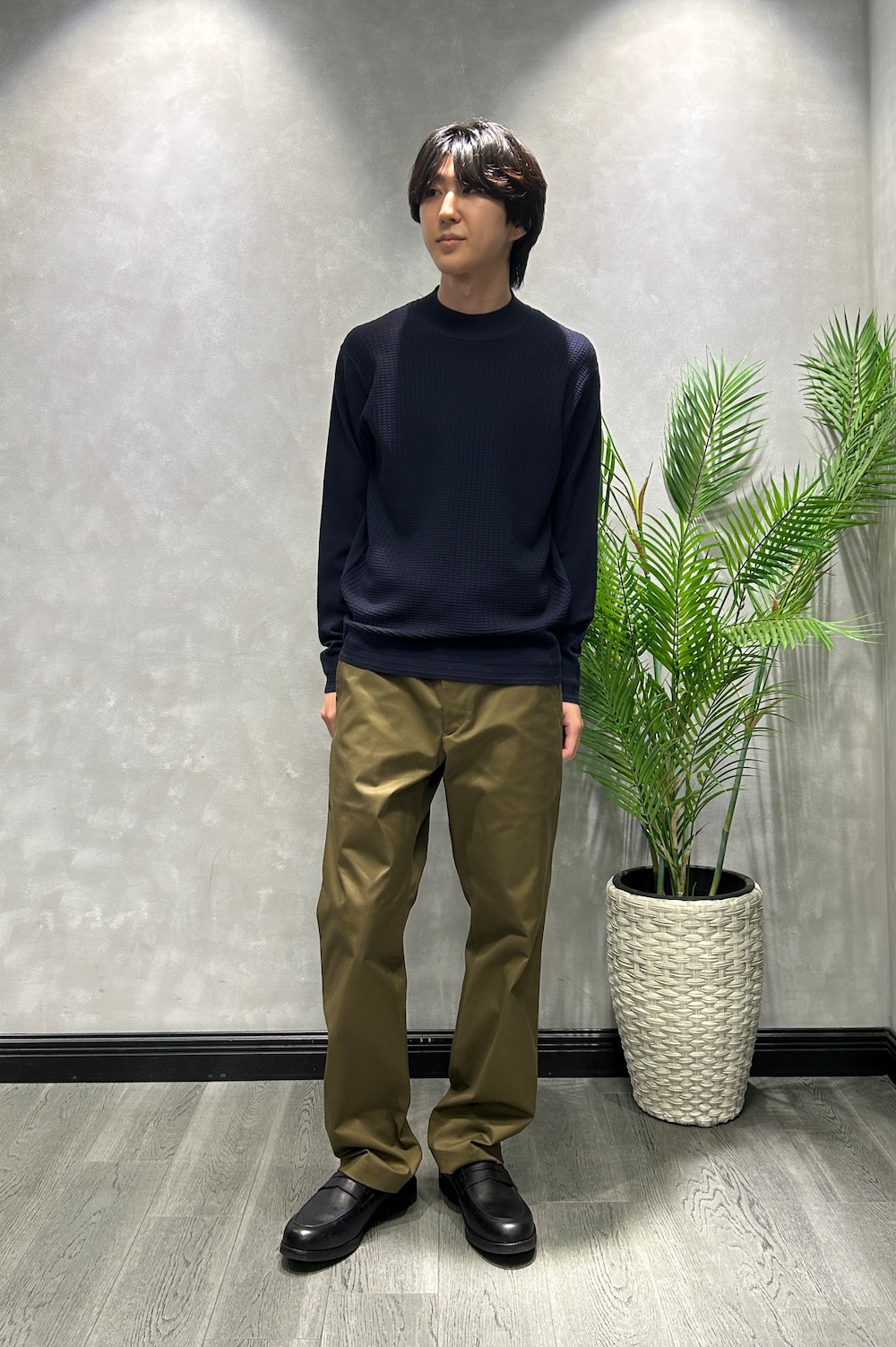 ブラック系のカーディガン/ボレロ、ブルー系のニット/セーター、グリーン系のスラックスを着用したメンズの秋コーディネートの6枚目の写真