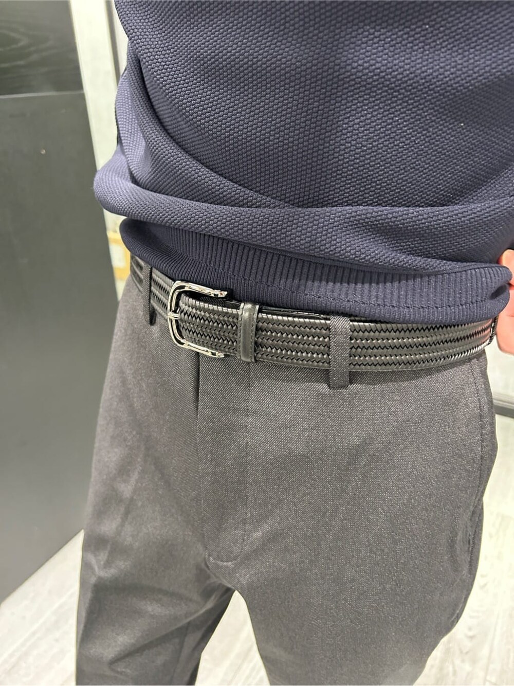 グレー系のその他アウター、ブラック系のスラックス、ブルー系のニット/セーターを着用したメンズの冬コーディネートの8枚目の写真