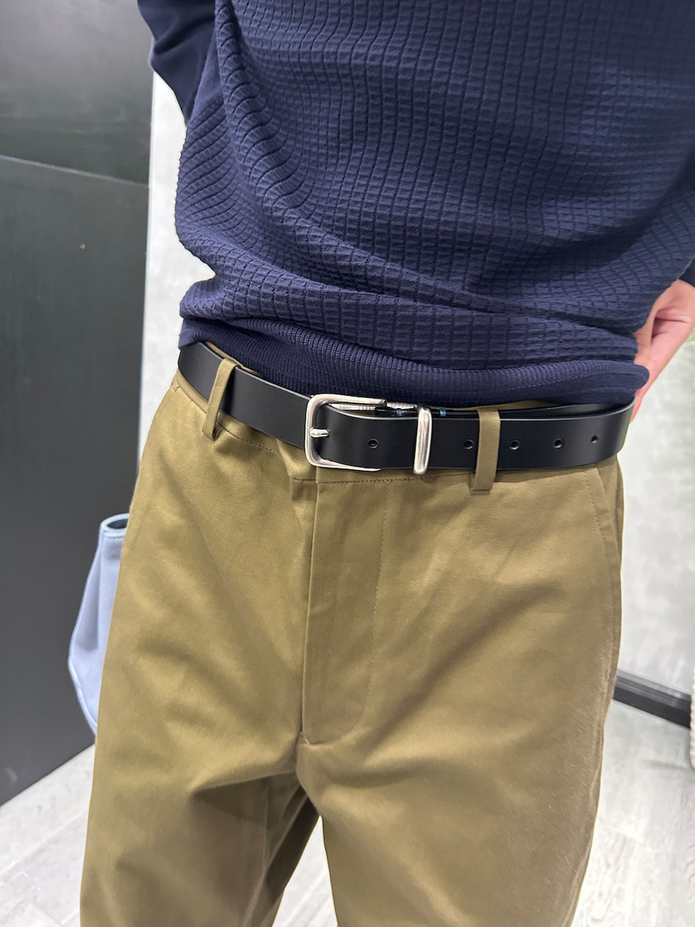 ブラック系のカーディガン/ボレロ、ブルー系のニット/セーター、グリーン系のスラックスを着用したメンズの秋コーディネートの9枚目の写真