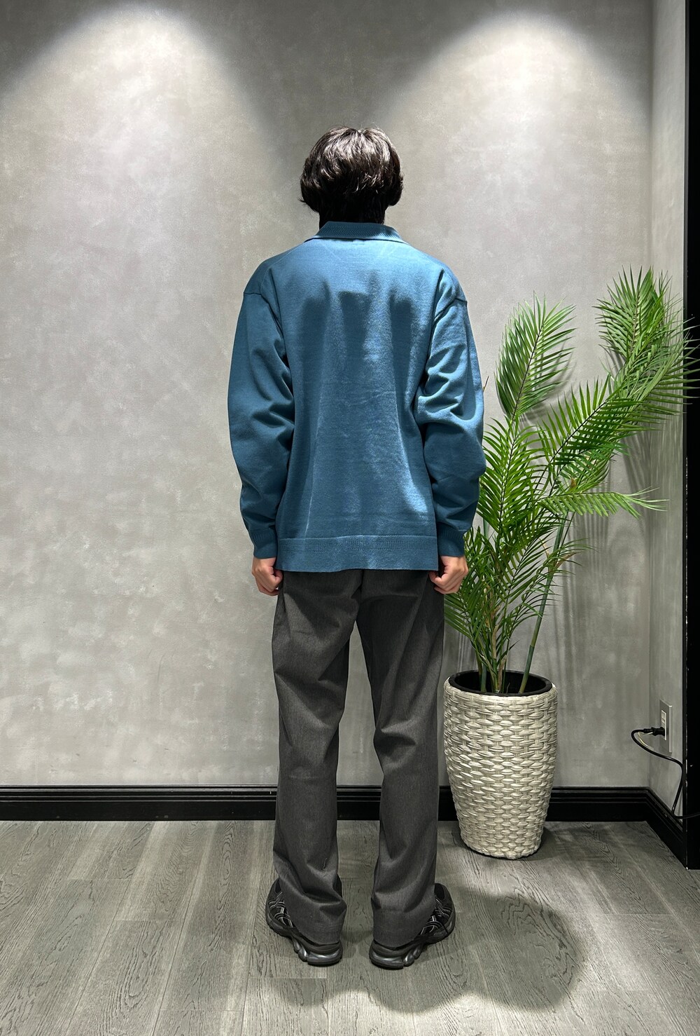 ブルー系のニット/セーター、ブラック系のTシャツ/カットソー、グレー系のスラックスを着用したメンズの秋コーディネートの3枚目の写真