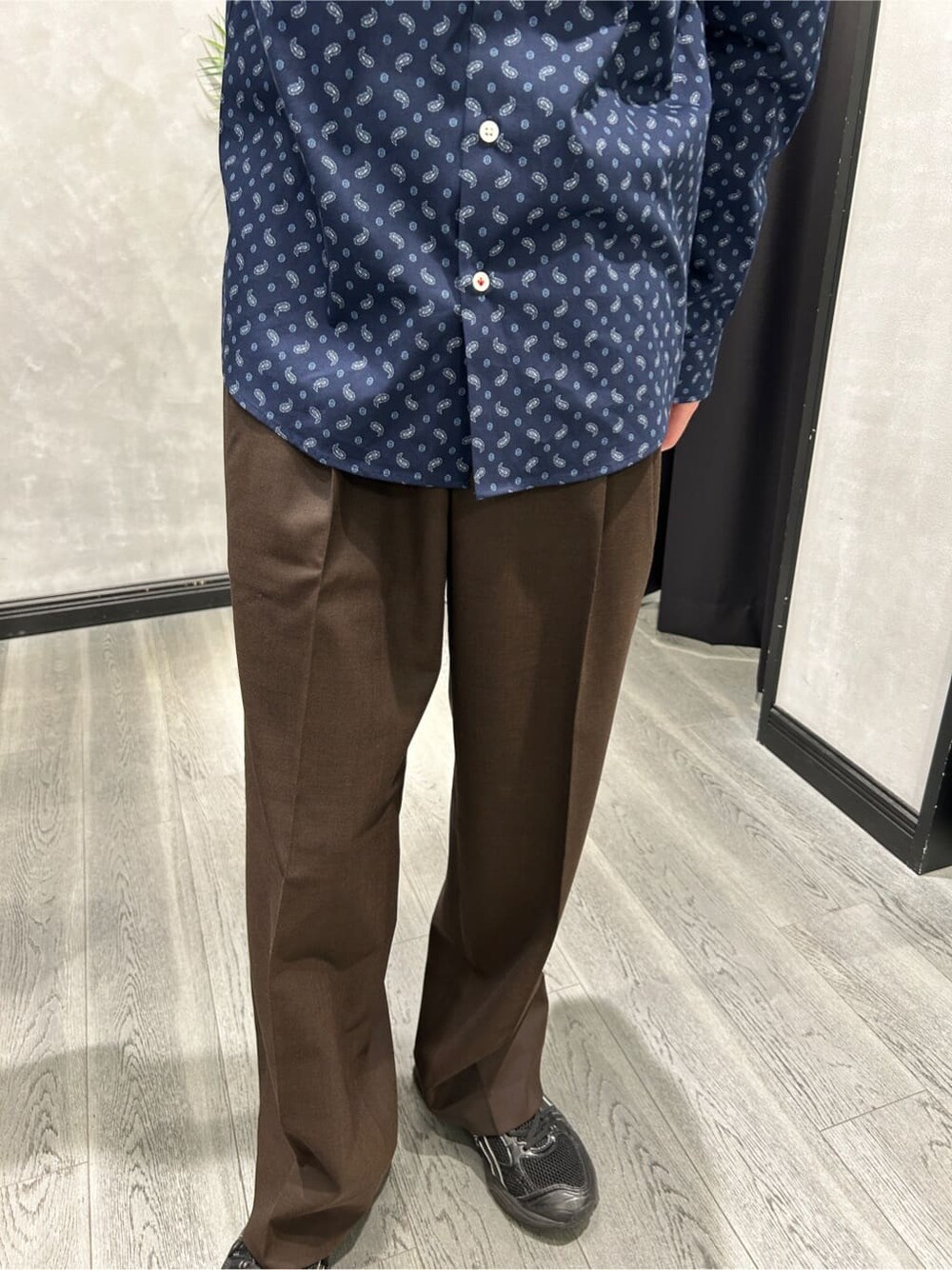 グレー系のブルゾン、ブルー系のシャツ/ブラウス、ブラウン系のスラックスを着用したメンズの春コーディネートの9枚目の写真