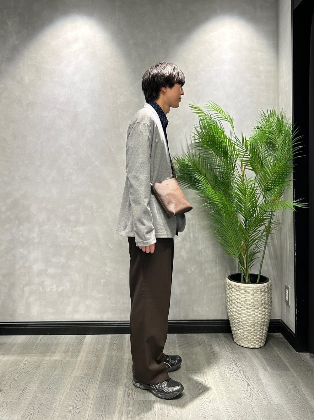 グレー系のカーディガン/ボレロ、ブルー系のシャツ/ブラウス、ブラウン系のスラックスを着用したメンズの春コーディネートの2枚目の写真