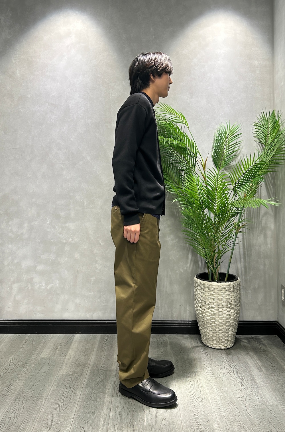 ブラック系のカーディガン/ボレロ、ブルー系のニット/セーター、グリーン系のスラックスを着用したメンズの秋コーディネートの2枚目の写真