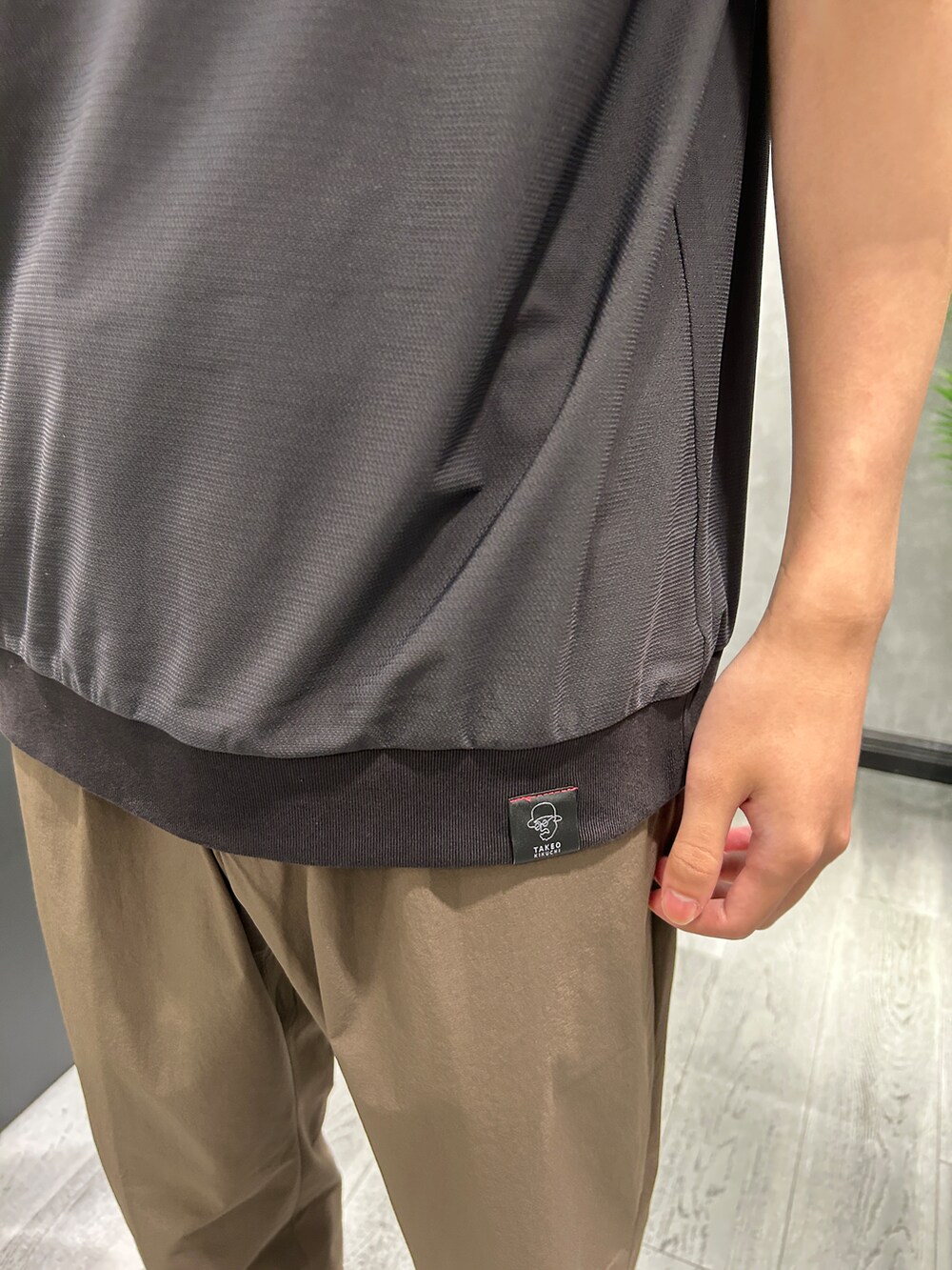 グレー系のテーラードジャケット、ブラック系のTシャツ/カットソー、ブラウン系のスラックスを着用したメンズの夏コーディネートの6枚目の写真