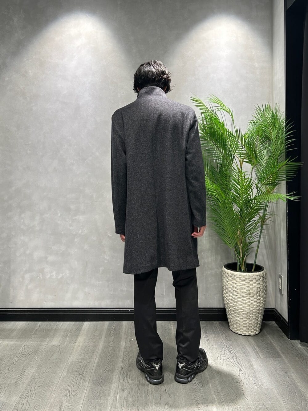 グレー系のその他アウター、ブラック系のスラックス、ブルー系のニット/セーターを着用したメンズの冬コーディネートの3枚目の写真
