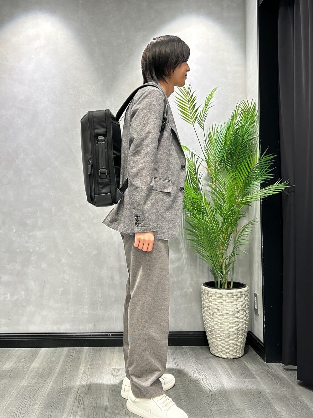 ブラック系のテーラードジャケット、ブラック系のスラックス、グレー系のバックパック/リュックを着用したメンズの夏コーディネートの2枚目の写真