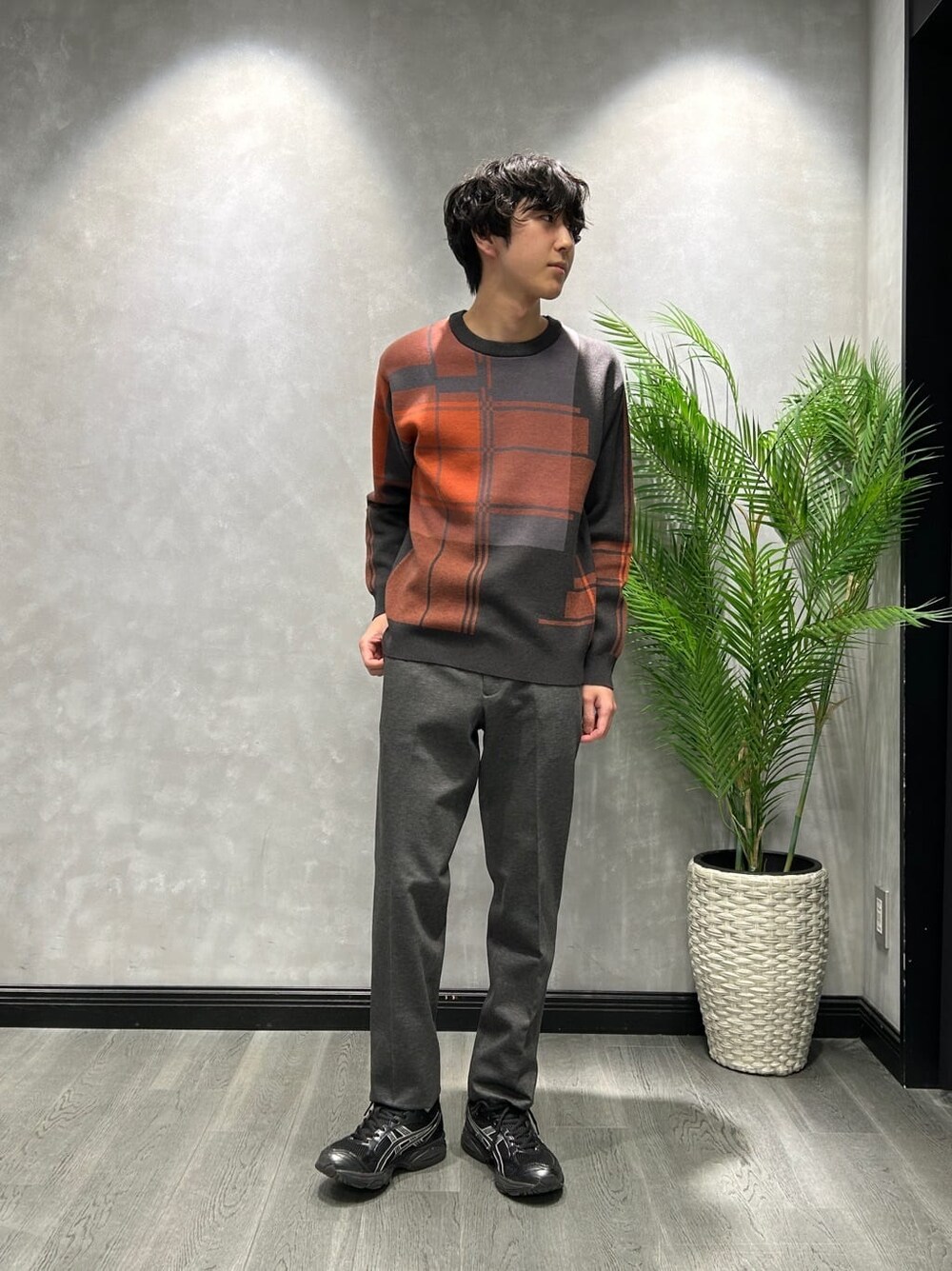 ブラック系のダウンジャケット/コート、グレー系のニット/セーター、ブラック系のスラックスを着用したメンズの冬コーディネートの6枚目の写真
