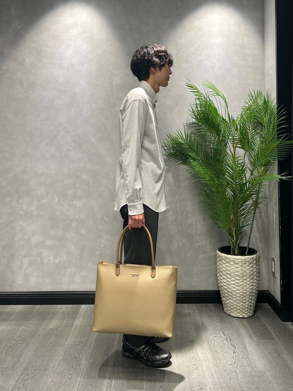 グレー系のシャツ/ブラウス、ブラック系のスラックス、ベージュ系のトートバッグを着用したメンズの冬コーディネートの2枚目の写真