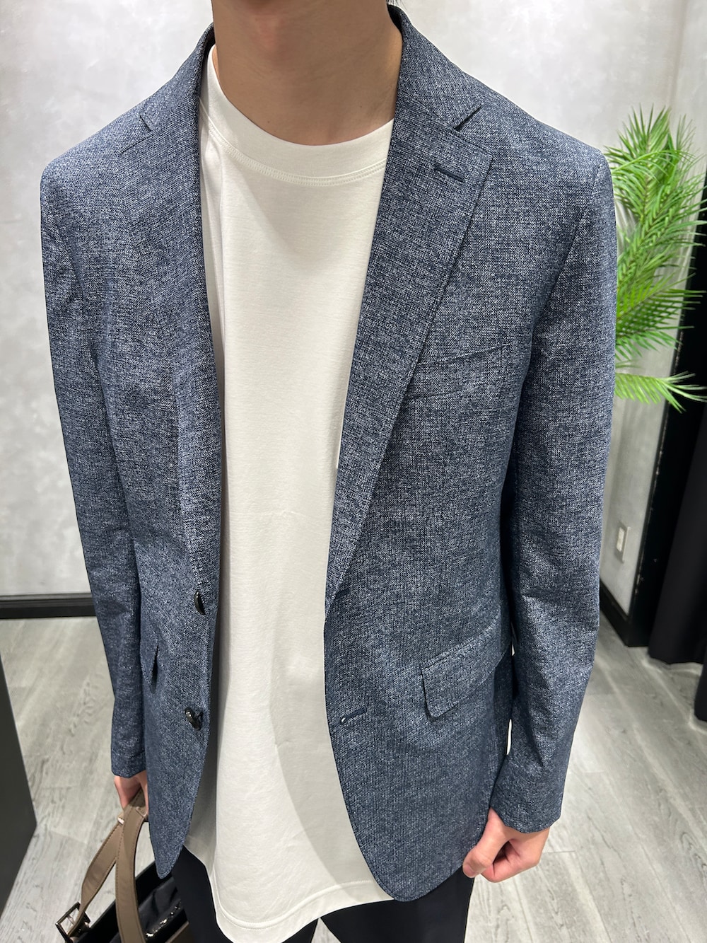 ブルー系のテーラードジャケット、ホワイト系のTシャツ/カットソー、ブルー系のスラックスを着用したメンズの夏コーディネートの4枚目の写真