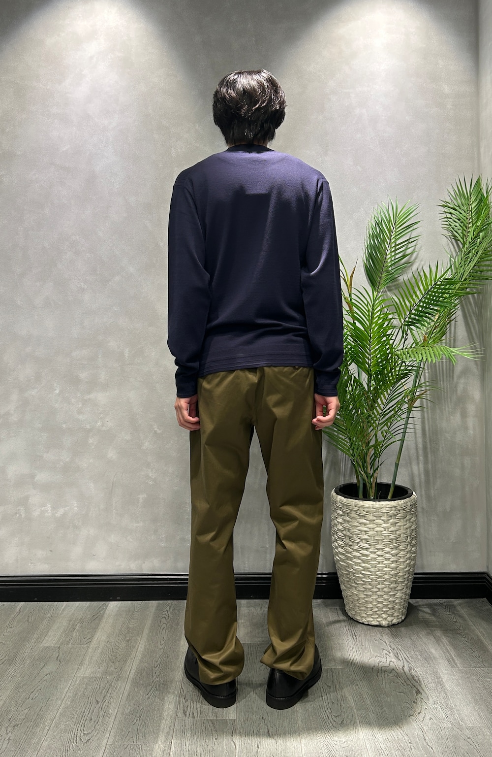 ブラック系のカーディガン/ボレロ、ブルー系のニット/セーター、グリーン系のスラックスを着用したメンズの秋コーディネートの7枚目の写真