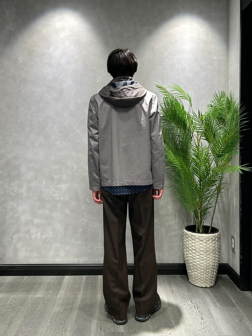 グレー系のブルゾン、ブルー系のシャツ/ブラウス、ブラウン系のスラックスを着用したメンズの春コーディネートの3枚目の写真