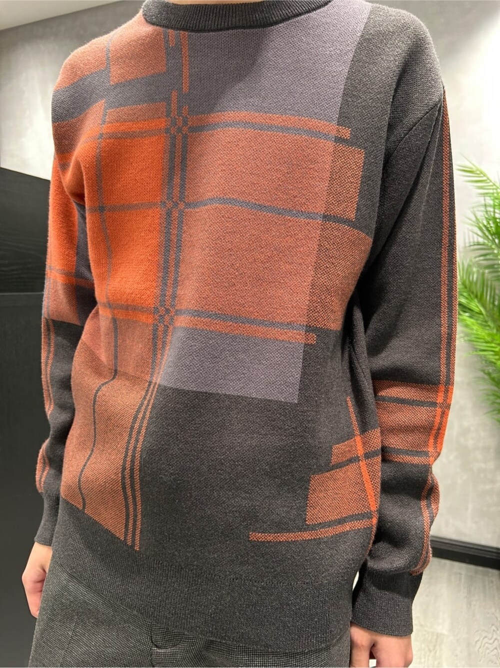 ブラック系のダウンジャケット/コート、グレー系のニット/セーター、ブラック系のスラックスを着用したメンズの冬コーディネートの8枚目の写真