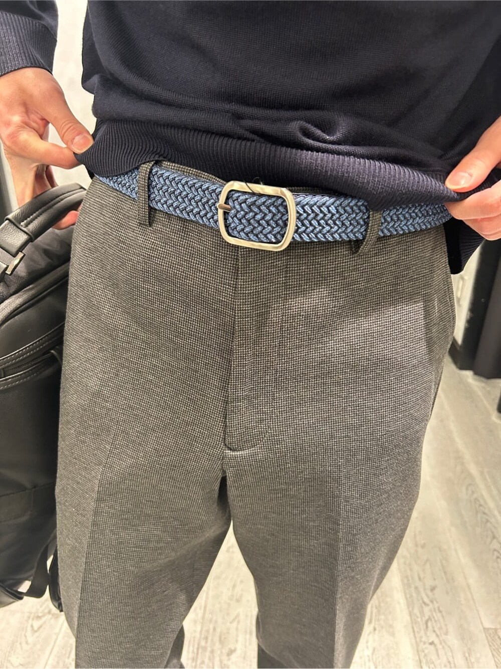 ブルー系のニット/セーター、ブラック系のスラックス、ブラック系のバックパック/リュックを着用したメンズの冬コーディネートの7枚目の写真