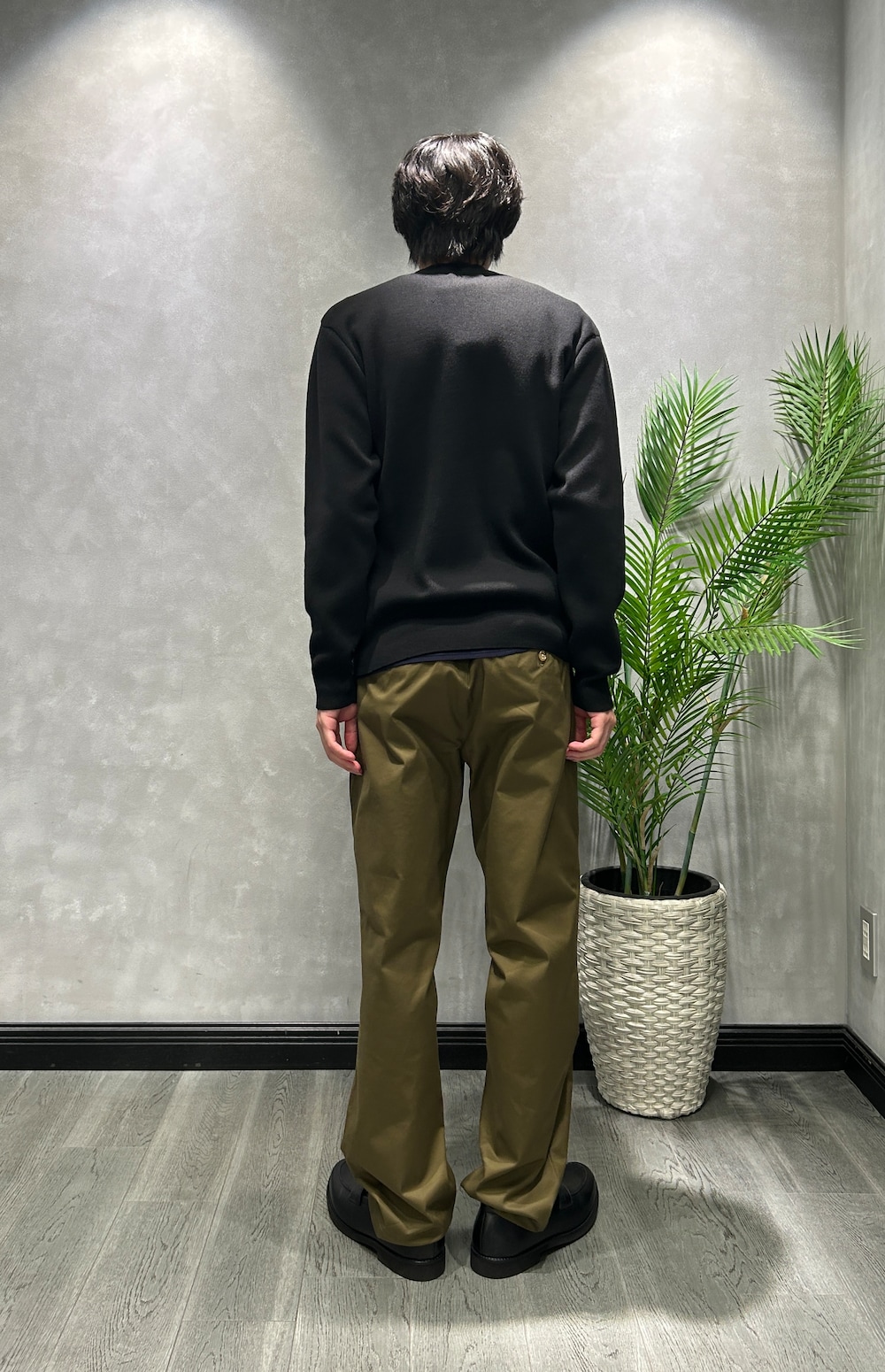 ブラック系のカーディガン/ボレロ、ブルー系のニット/セーター、グリーン系のスラックスを着用したメンズの秋コーディネートの3枚目の写真