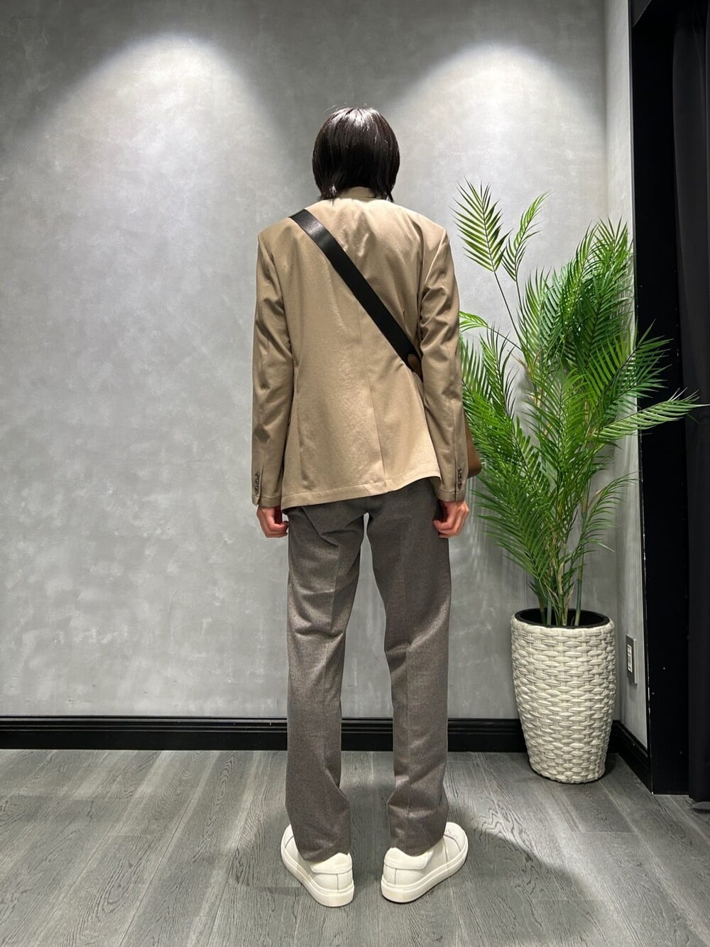 ベージュ系のテーラードジャケット、ブラック系のスラックス、ホワイト系のスニーカーを着用したメンズの秋コーディネートの3枚目の写真