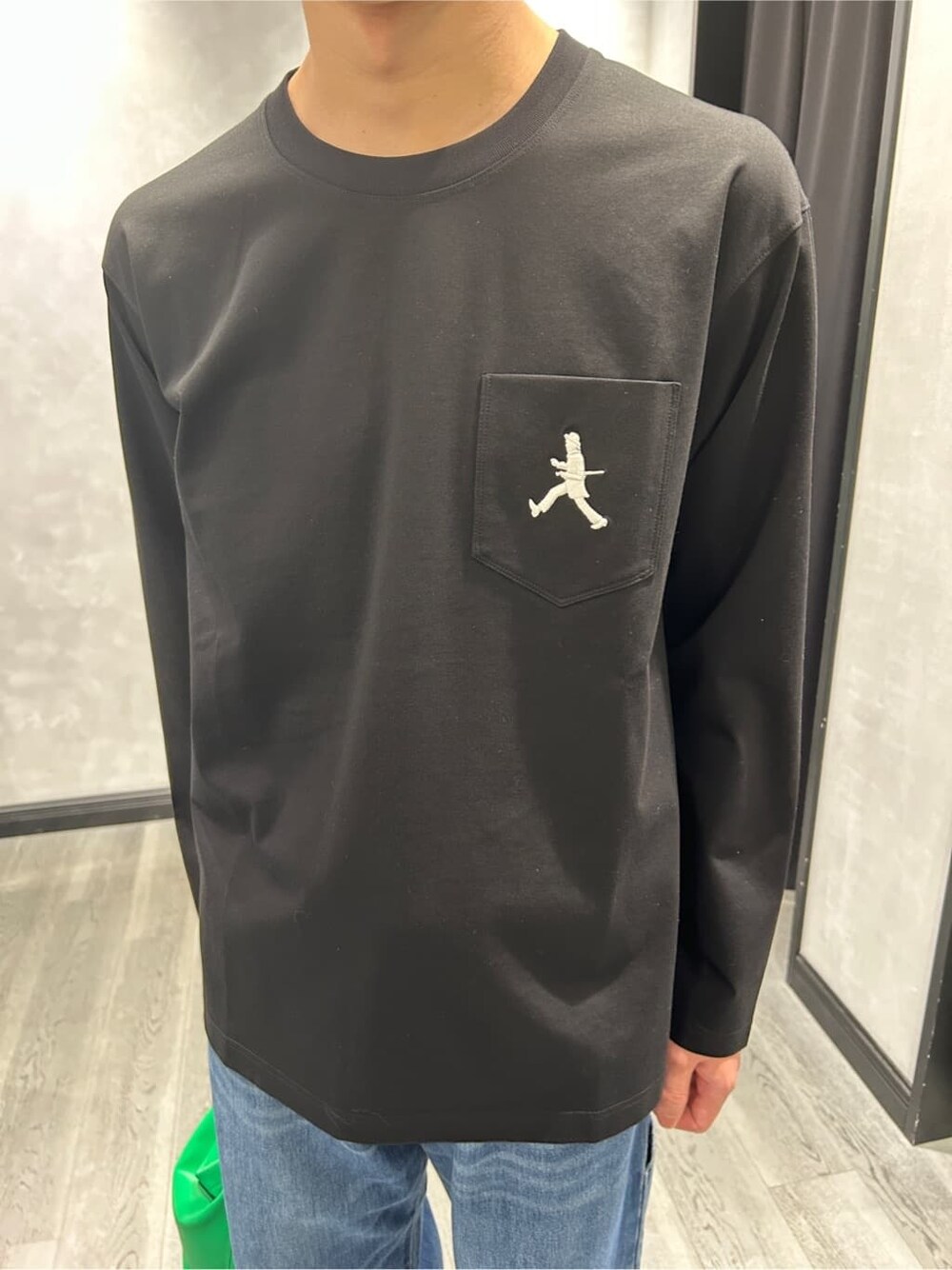ブラック系のブルゾン、ブラック系のTシャツ/カットソー、ブルー系のデニムパンツを着用したメンズの春コーディネートの7枚目の写真