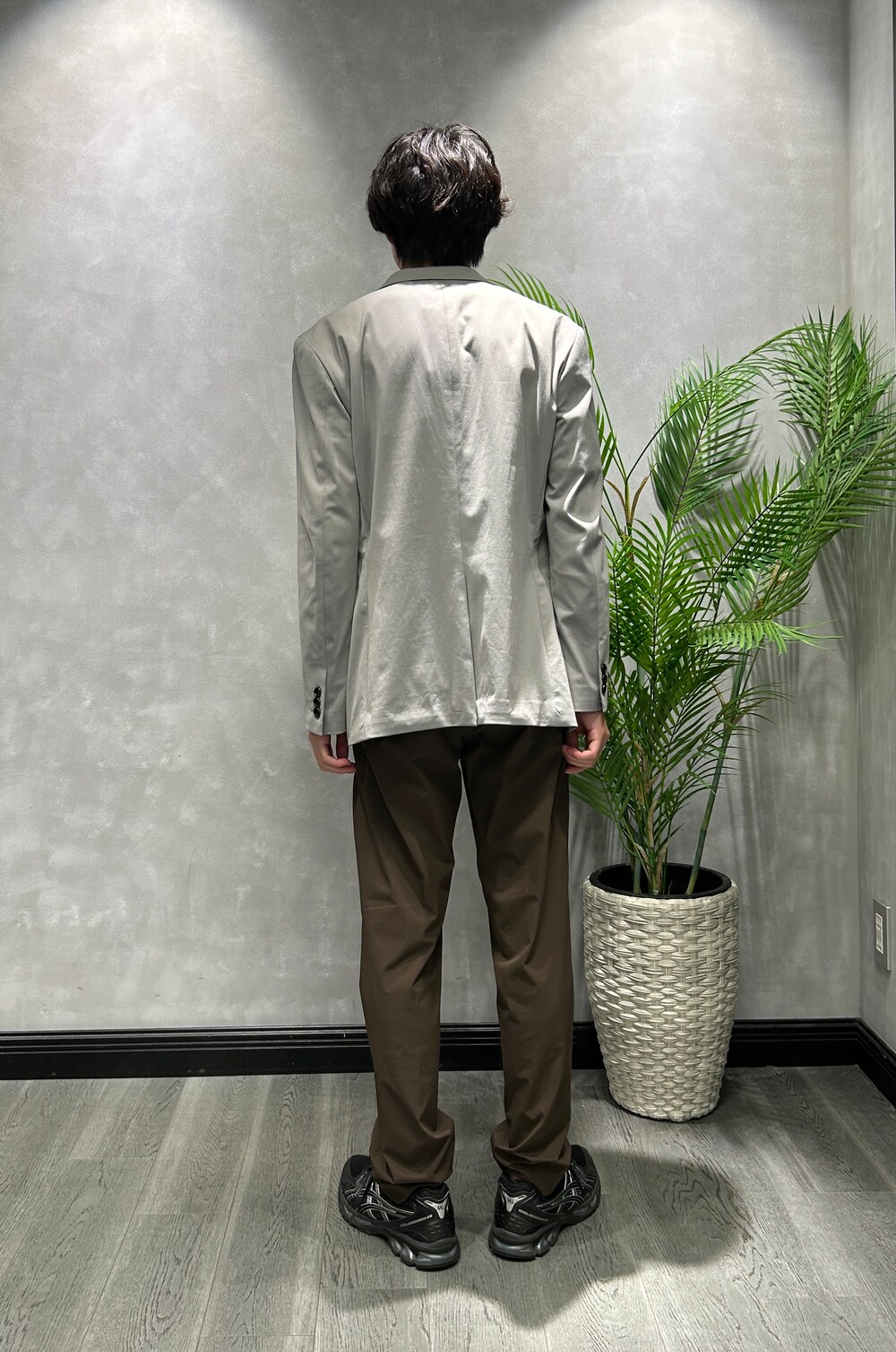 グレー系のテーラードジャケット、ブラック系のTシャツ/カットソー、ブラウン系のスラックスを着用したメンズの夏コーディネートの3枚目の写真