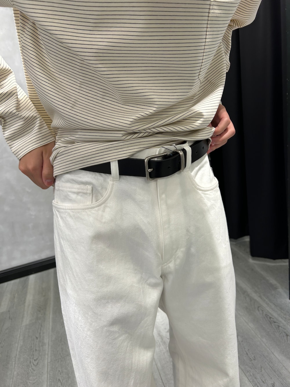 ブラック系のブルゾン、ホワイト系のTシャツ/カットソー、ホワイト系のデニムパンツを着用したメンズの秋コーディネートの6枚目の写真