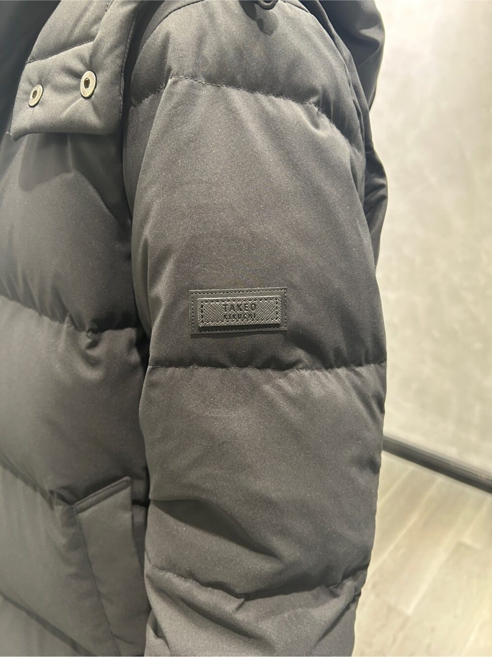 グレー系のシャツ/ブラウス、ブラック系のスラックス、ベージュ系のトートバッグを着用したメンズの冬コーディネートの4枚目の写真