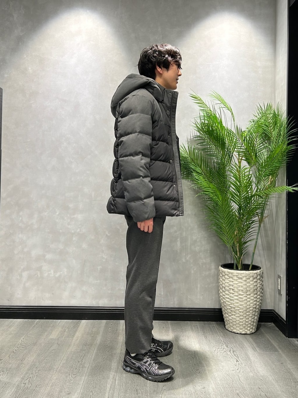 ブラック系のダウンジャケット/コート、グレー系のニット/セーター、ブラック系のスラックスを着用したメンズの冬コーディネートの2枚目の写真