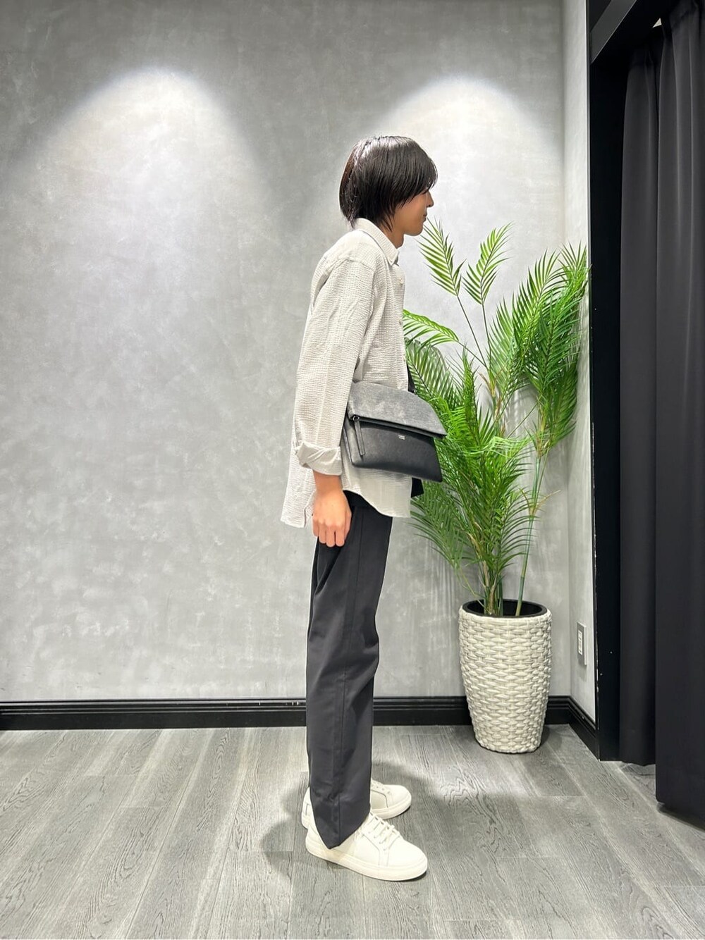 グレー系のシャツ/ブラウス、ブラック系のスラックス、ホワイト系のスニーカーを着用したメンズの秋コーディネートの2枚目の写真