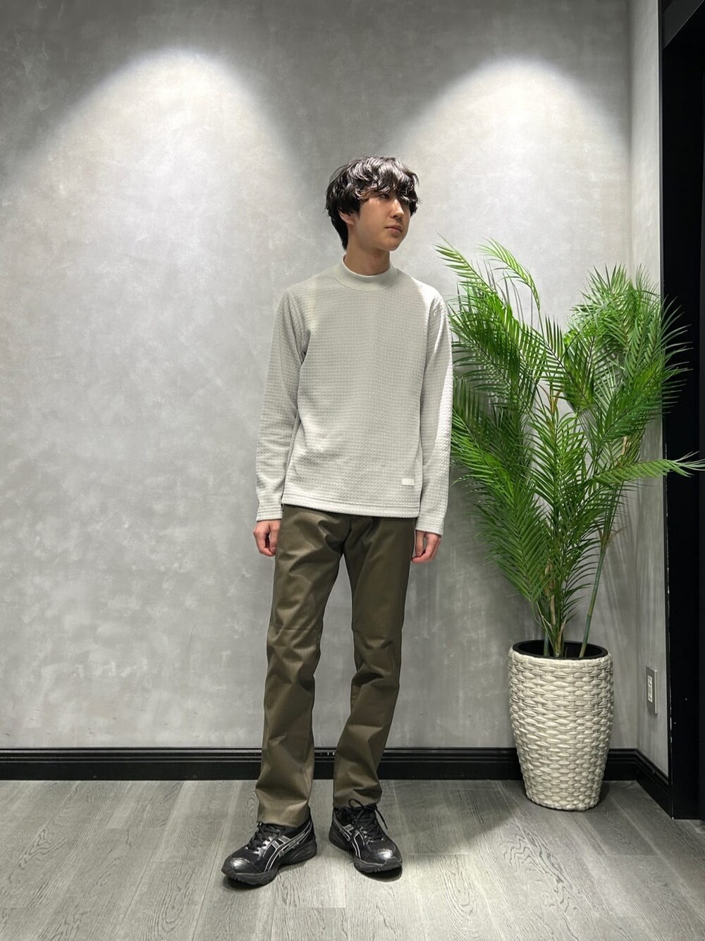 ブラウン系のステンカラーコート、グレー系のTシャツ/カットソー、グリーン系のスラックスを着用したメンズの冬コーディネートの6枚目の写真