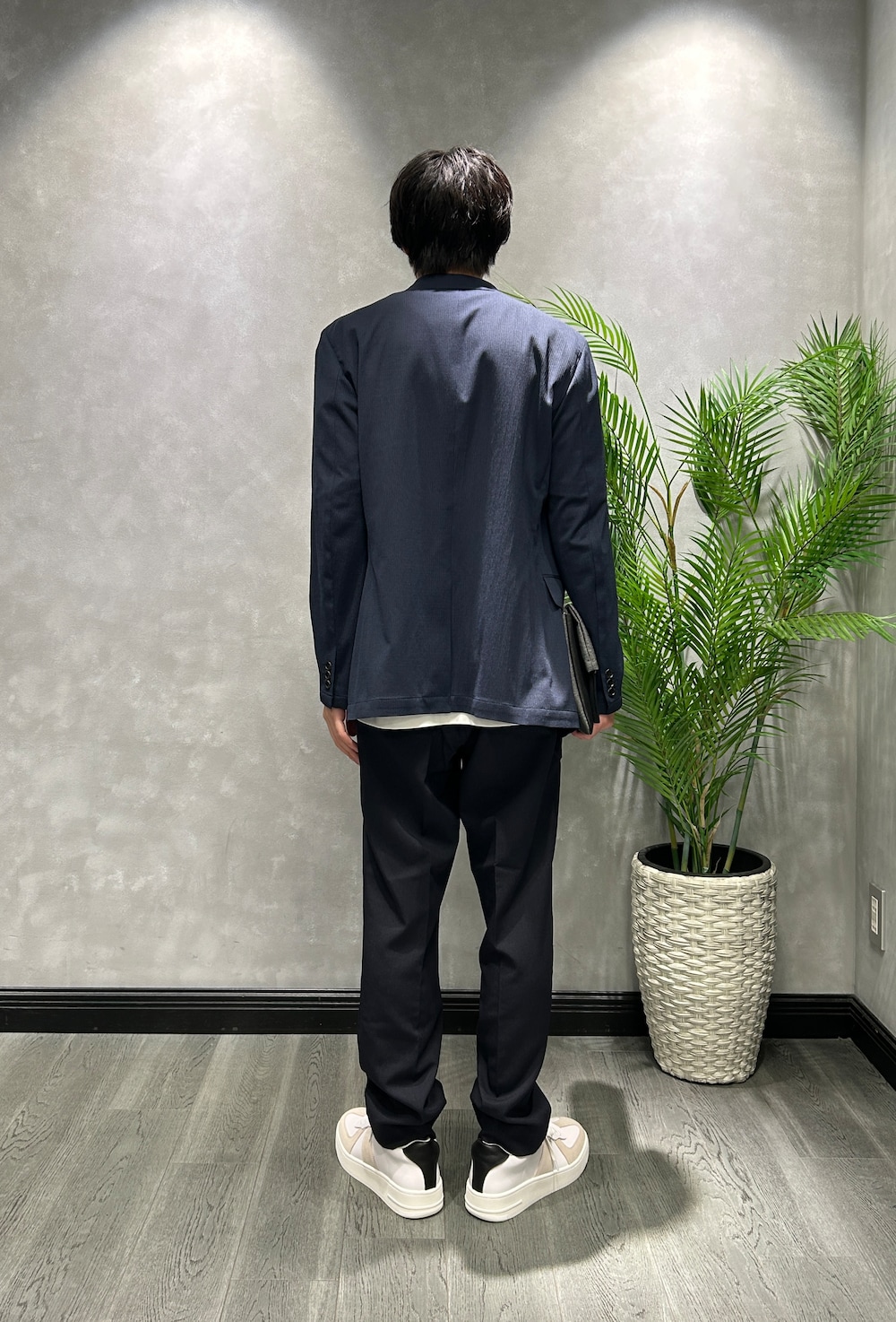 ブルー系のテーラードジャケット、ホワイト系のTシャツ/カットソー、ブルー系のスラックスを着用したメンズの夏コーディネートの3枚目の写真
