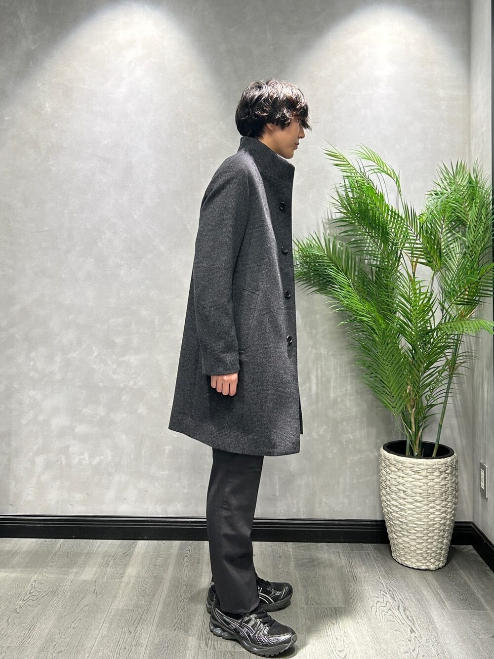 グレー系のその他アウター、ブラック系のスラックス、ブルー系のニット/セーターを着用したメンズの冬コーディネートの2枚目の写真