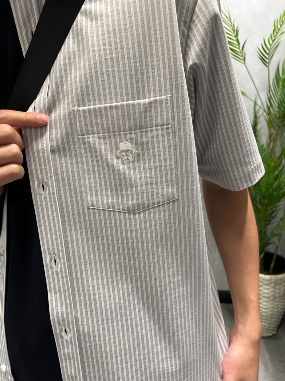 グレー系のシャツ/ブラウス、ブルー系のTシャツ/カットソー、ブラック系のスラックスを着用したメンズの夏コーディネートの4枚目の写真