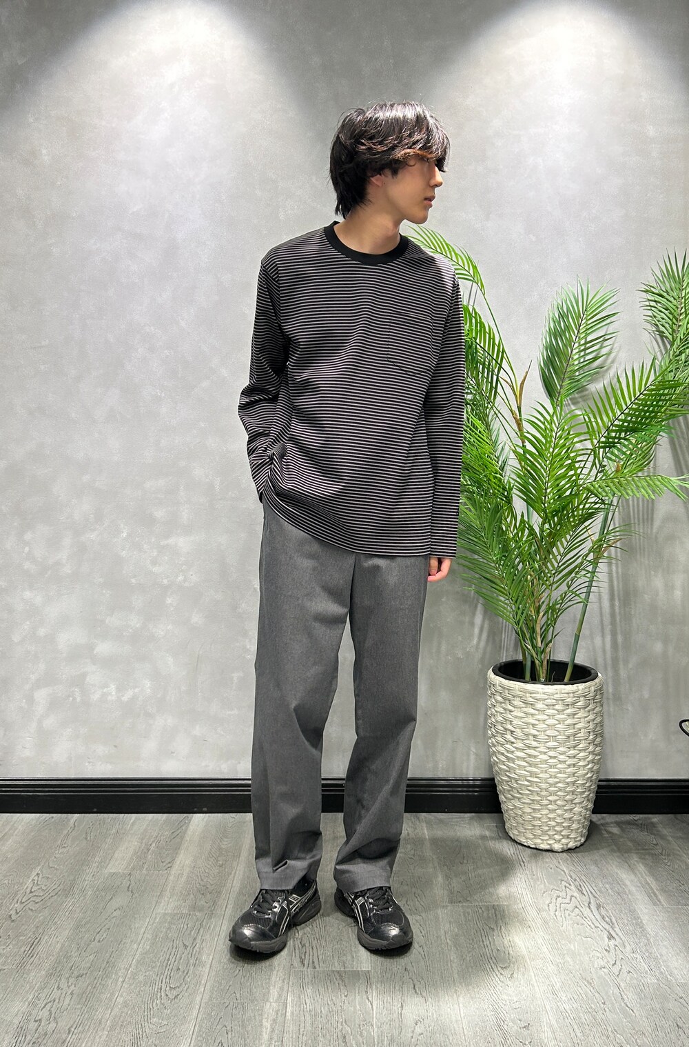 ブラック系のブルゾン、ブラック系のTシャツ/カットソー、グレー系のスラックスを着用したメンズの秋コーディネートの7枚目の写真