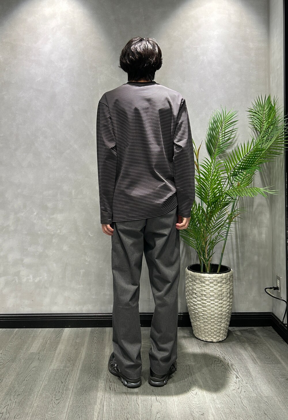 ブラック系のブルゾン、ブラック系のTシャツ/カットソー、グレー系のスラックスを着用したメンズの秋コーディネートの8枚目の写真