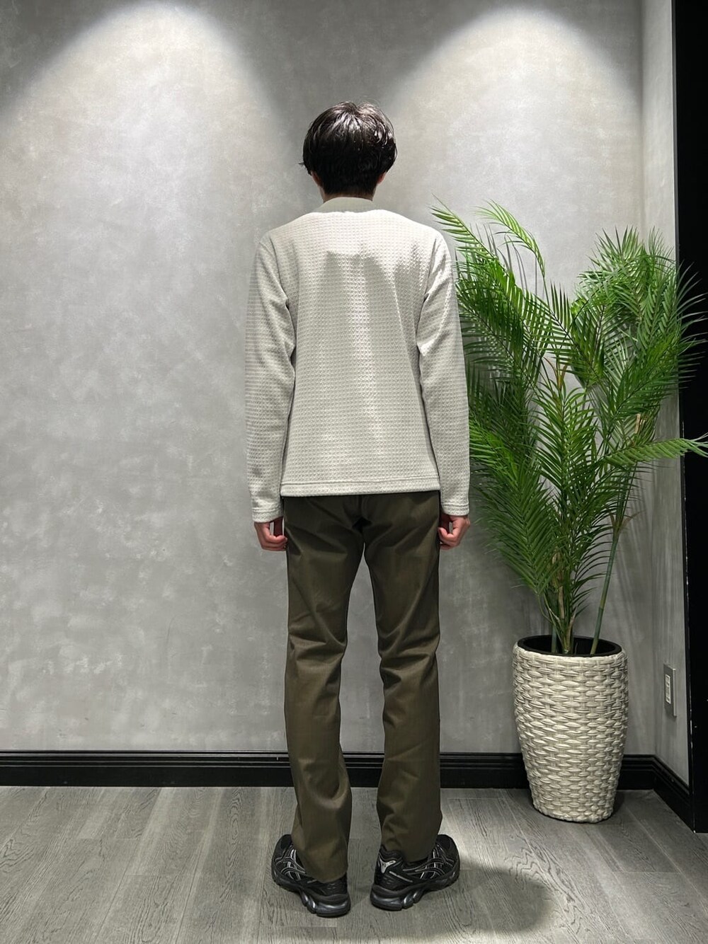 ブラウン系のステンカラーコート、グレー系のTシャツ/カットソー、グリーン系のスラックスを着用したメンズの冬コーディネートの7枚目の写真