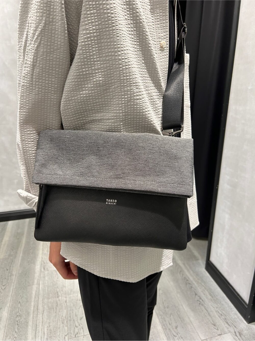 グレー系のシャツ/ブラウス、ブラック系のスラックス、ホワイト系のスニーカーを着用したメンズの秋コーディネートの4枚目の写真