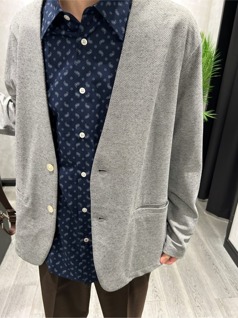 グレー系のカーディガン/ボレロ、ブルー系のシャツ/ブラウス、ブラウン系のスラックスを着用したメンズの春コーディネートの4枚目の写真