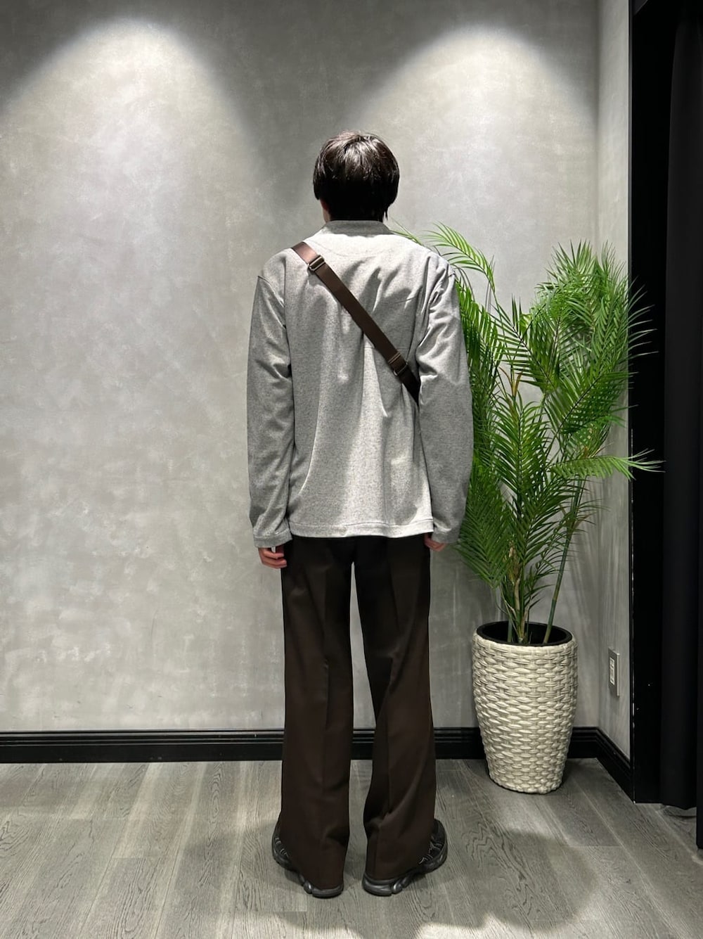 グレー系のカーディガン/ボレロ、ブルー系のシャツ/ブラウス、ブラウン系のスラックスを着用したメンズの春コーディネートの3枚目の写真