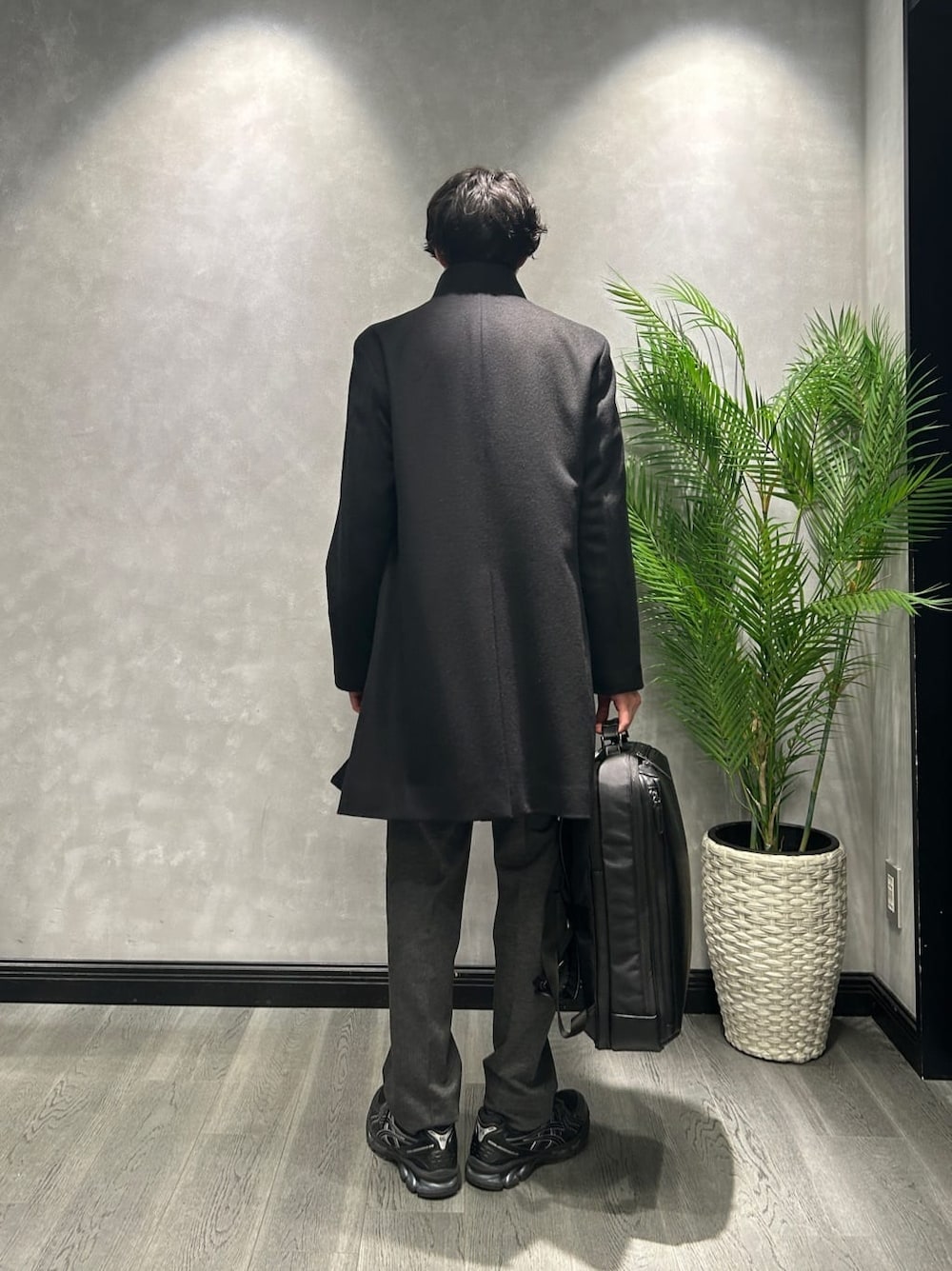 ブラック系のその他アウター、ブルー系のニット/セーター、ブラック系のスラックスを着用したメンズの冬コーディネートの3枚目の写真