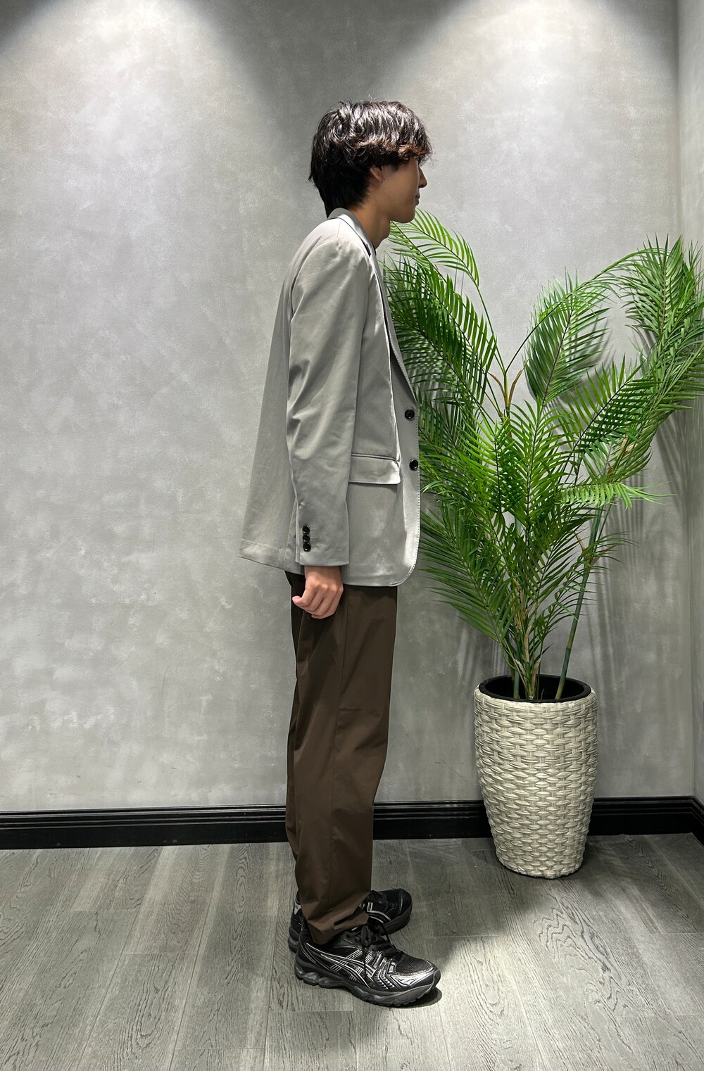 グレー系のテーラードジャケット、ブラック系のTシャツ/カットソー、ブラウン系のスラックスを着用したメンズの夏コーディネートの2枚目の写真