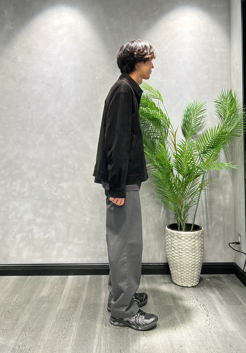 ブラック系のブルゾン、ブラック系のTシャツ/カットソー、グレー系のスラックスを着用したメンズの秋コーディネートの2枚目の写真