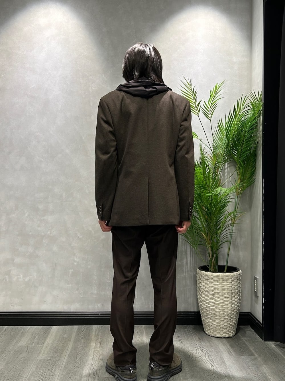 ブラウン系のテーラードジャケット、ブラック系のブルゾン、グレー系のポロシャツを着用したメンズの秋コーディネートの3枚目の写真