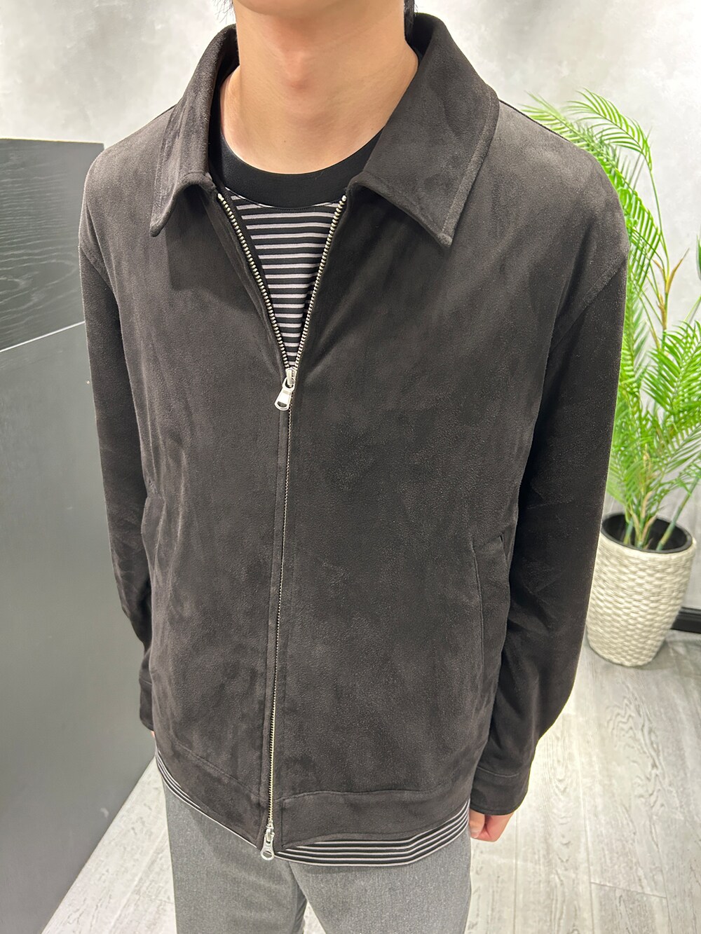 ブラック系のブルゾン、ブラック系のTシャツ/カットソー、グレー系のスラックスを着用したメンズの秋コーディネートの4枚目の写真