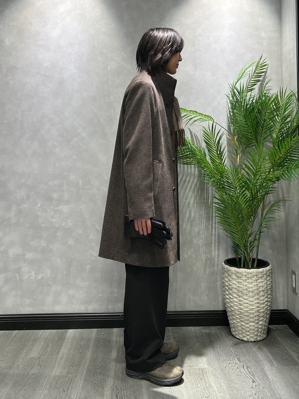 ブラウン系のその他アウター、グレー系のニット/セーター、オレンジ系のマフラーを着用したメンズの秋コーディネートの2枚目の写真