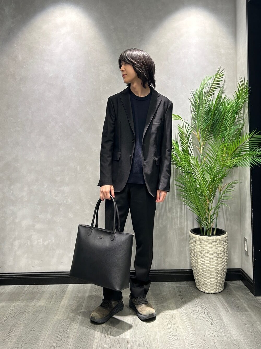 ベージュ系のダウンジャケット/コート、ブルー系のニット/セーター、ブラック系のトートバッグを着用したメンズの秋コーディネートの8枚目の写真