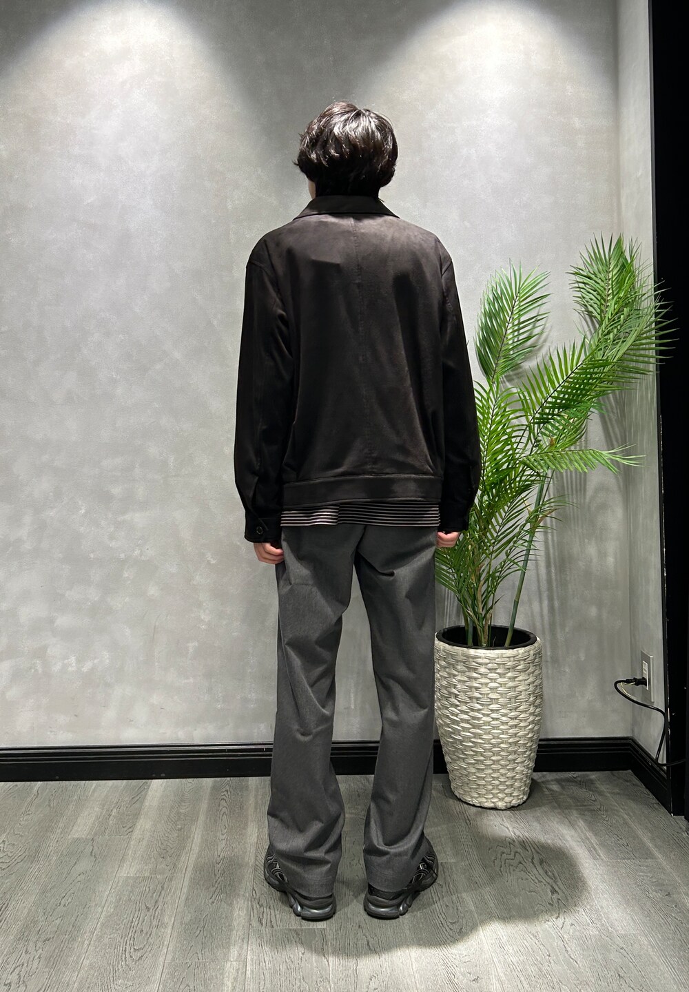ブラック系のブルゾン、ブラック系のTシャツ/カットソー、グレー系のスラックスを着用したメンズの秋コーディネートの3枚目の写真