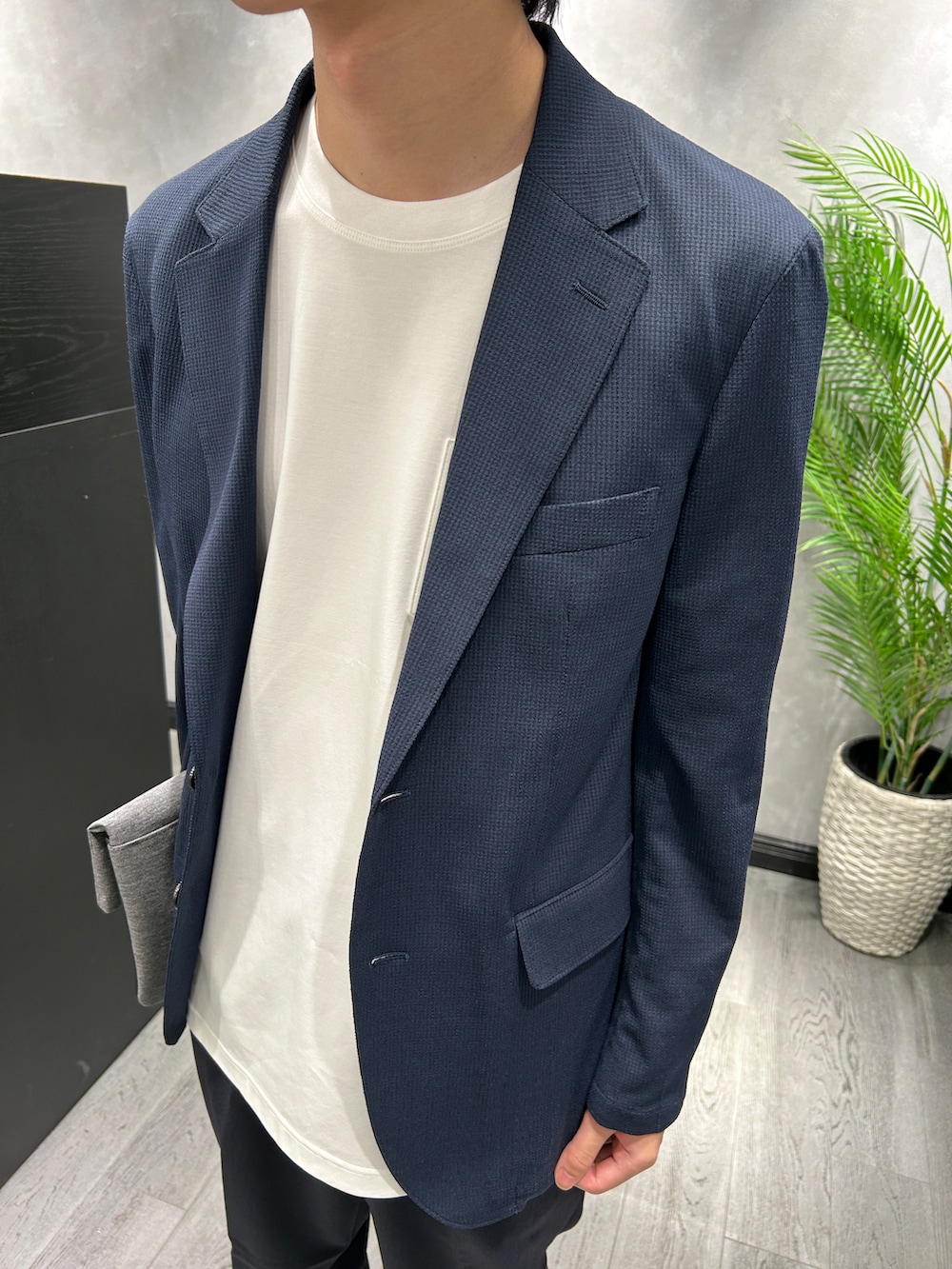 ブルー系のテーラードジャケット、ホワイト系のTシャツ/カットソー、ブルー系のスラックスを着用したメンズの夏コーディネートの4枚目の写真