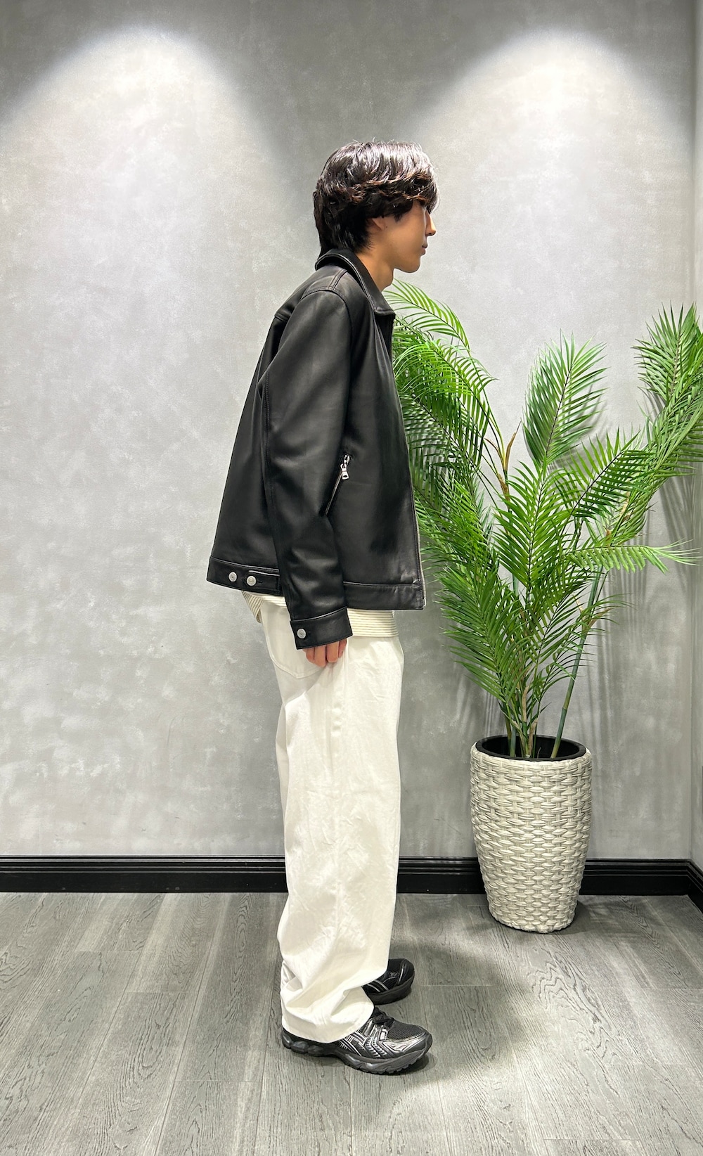 ブラック系のブルゾン、ホワイト系のTシャツ/カットソー、ホワイト系のデニムパンツを着用したメンズの秋コーディネートの2枚目の写真