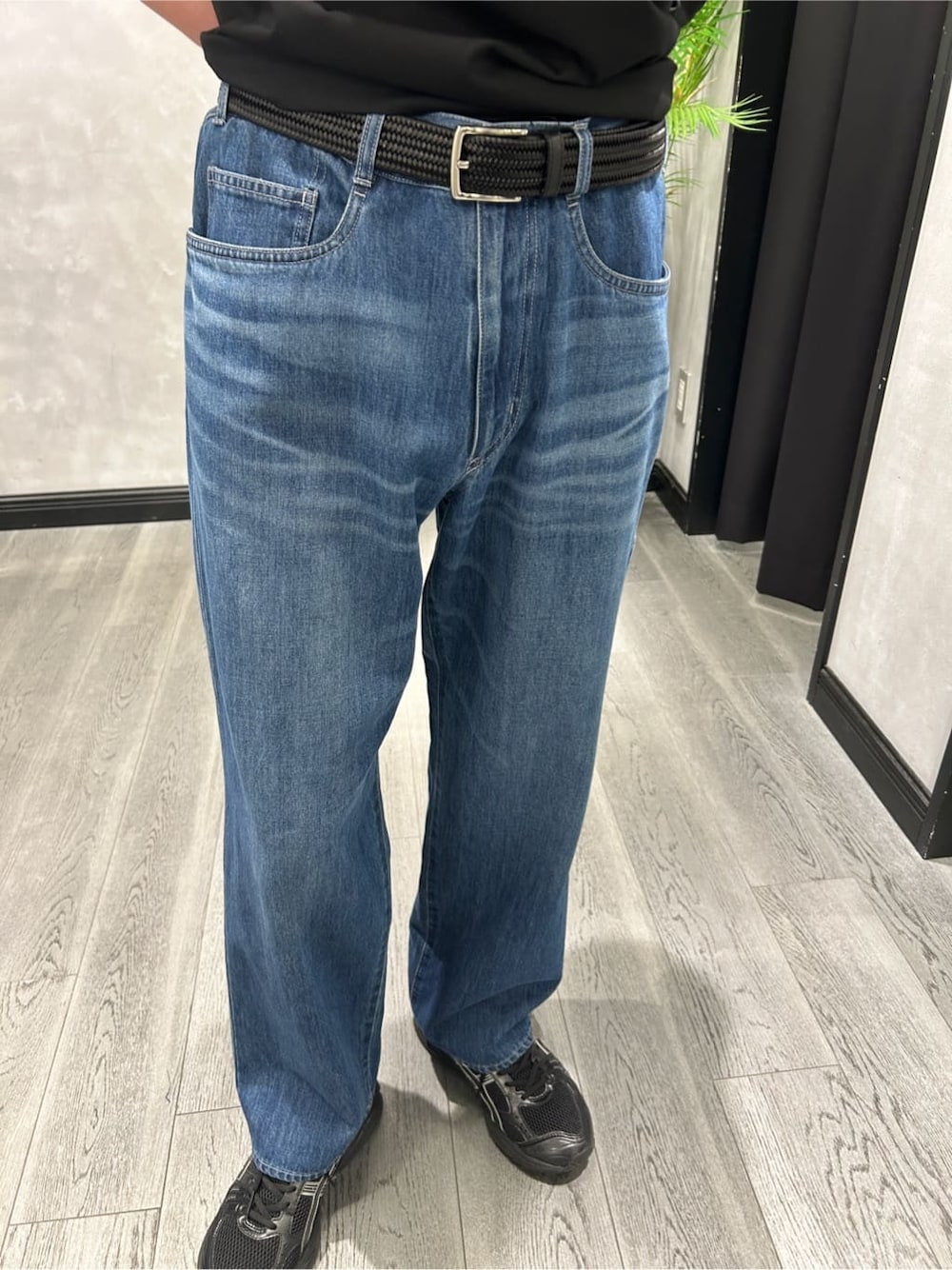 ブラック系のブルゾン、ブラック系のTシャツ/カットソー、ブルー系のデニムパンツを着用したメンズの春コーディネートの8枚目の写真