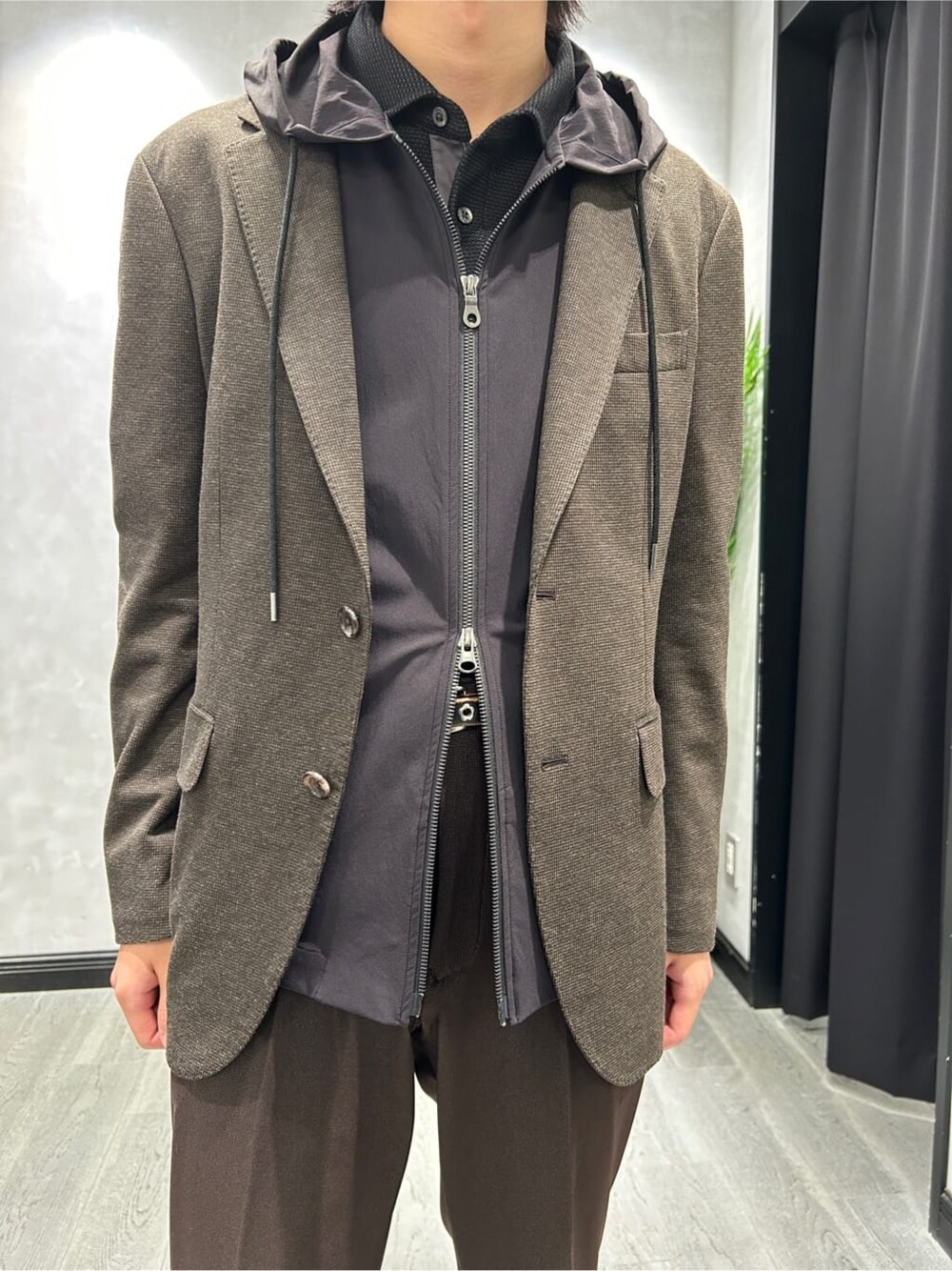 ブラウン系のテーラードジャケット、ブラック系のブルゾン、グレー系のポロシャツを着用したメンズの秋コーディネートの4枚目の写真